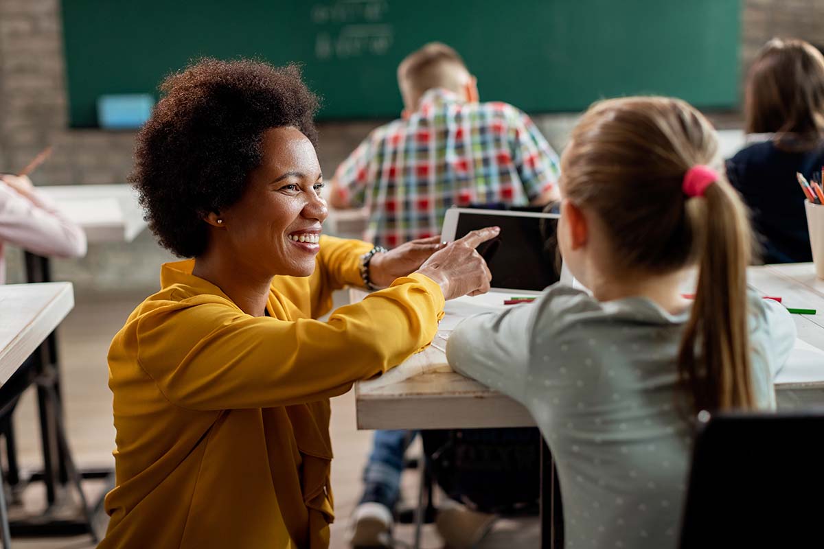 teacher-schoolgirl-using-digital-tablet-classroom